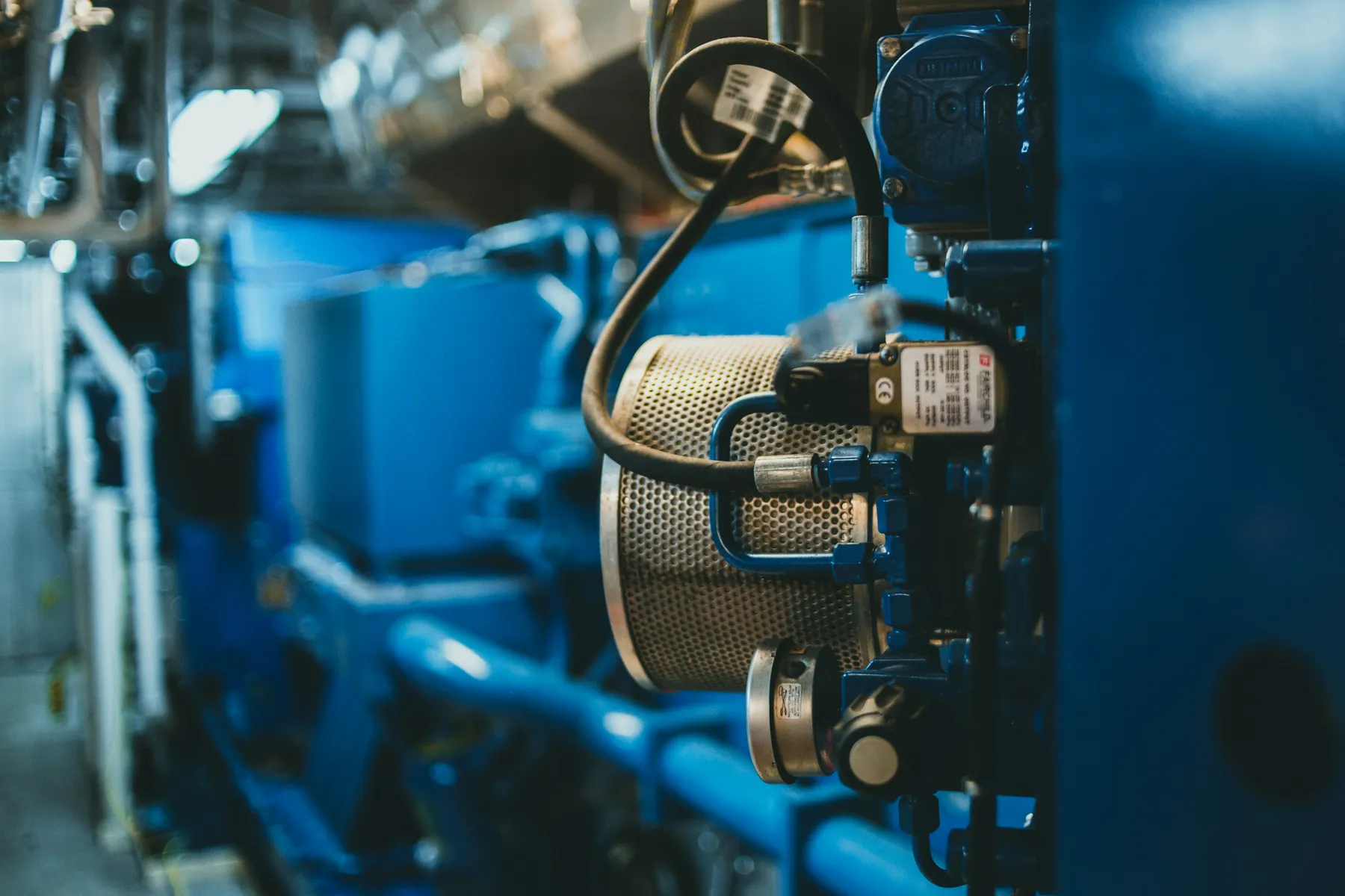 Close-up of components on a blue industrial generator engine